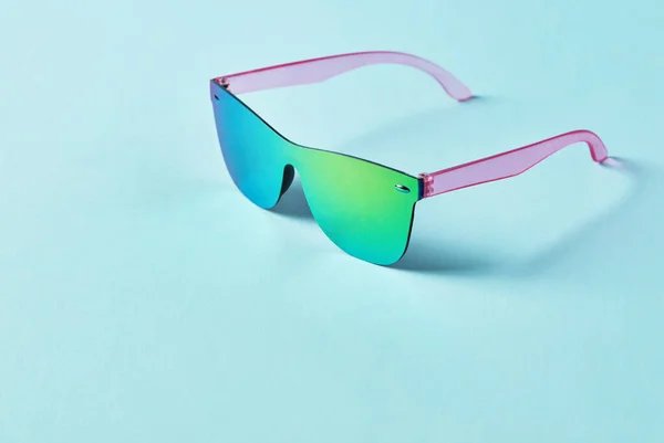 Summer multi-colored sunglasses on blue background